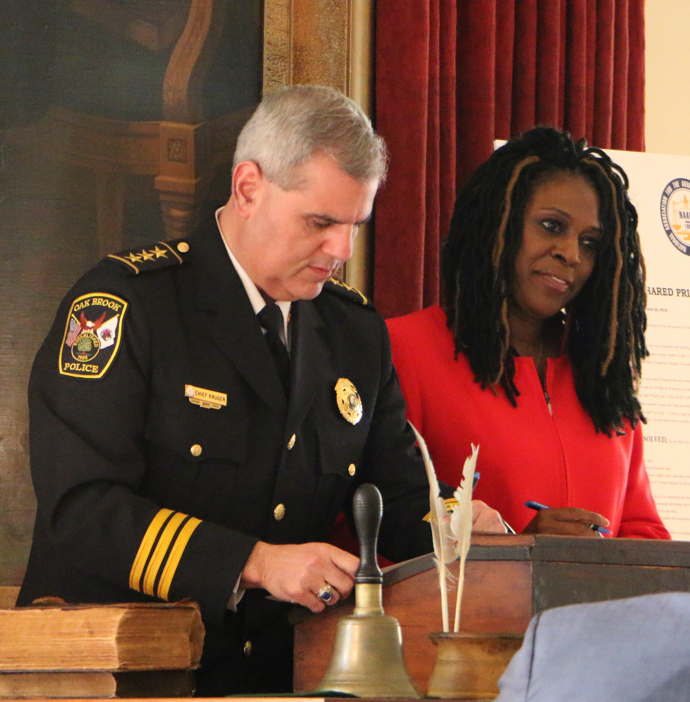 Kruger signing Ten Shared Principles in 2018, pictured with NAACP State President Teresa Haley. 